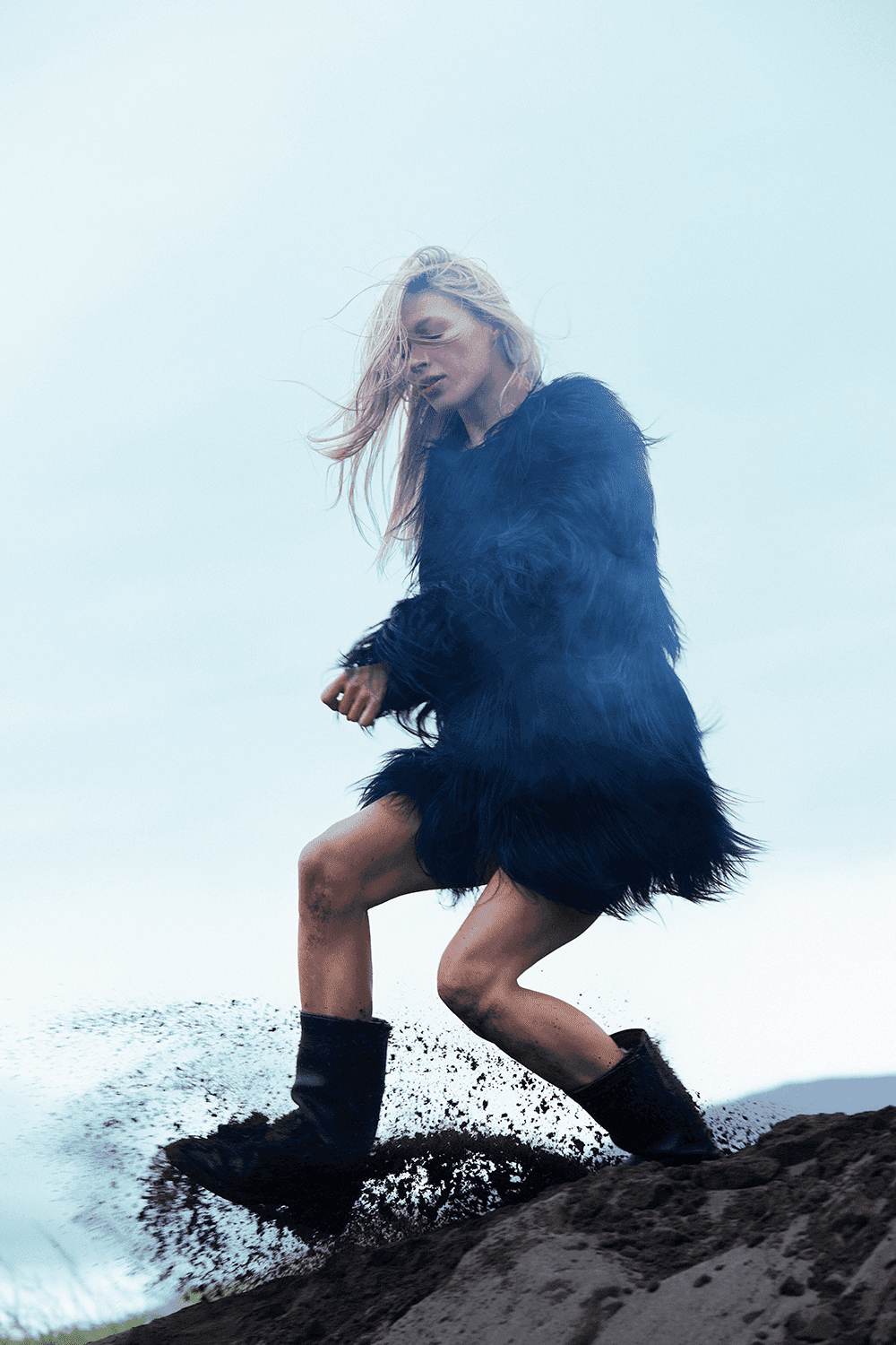 Editorial photo of a woman kicking sand